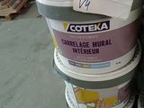several buckets of paint sitting on top of each other in a warehouse