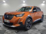 la voiture orange est garée dans le garage sur un sol en damier