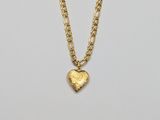 a gold necklace with a heart charm on a chain