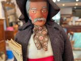 a figurine of a man with a newspaper in his hand