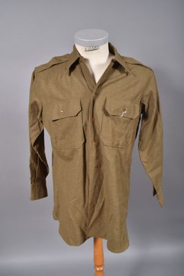 une chemise marron posée sur un présentoir à mannequin, sur fond gris