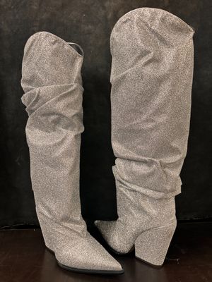 a pair of women ' s grey boots on a wooden floor