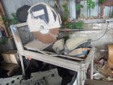 a pile of junk in a garage with a broken toilet seat