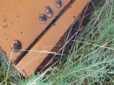 a rusted piece of luggage sitting in the grass