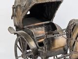 statue of a horse pulling a carriage with a man in the back