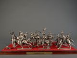 silver figurine of a group of knights on a red base