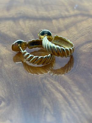 une bague en or posée sur une table en bois sur laquelle se trouve de l'eau