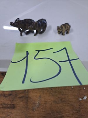two figurines of animals sitting on a table next to a sign