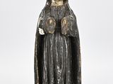 an old statue of a woman with a black robe and a white hat