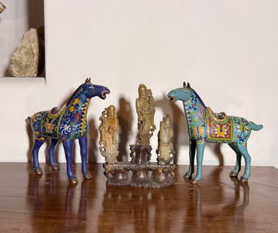 trois figurines de chevaux posées sur une table en bois