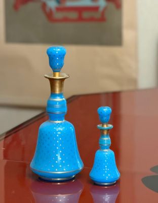 two blue vases sitting on a table next to each other