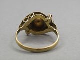 a close up of a gold ring with a red stone in the center