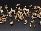 a lot of gold earrings on a black surface