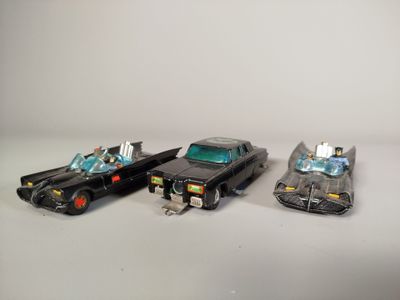 trois voitures jouets assises l'une à côté de l'autre sur une table