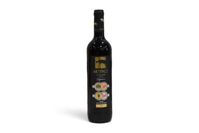 une bouteille de vin rouge posée sur une table blanche