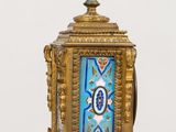 a blue and gold clock on a stand on a table