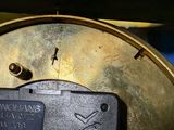 a close up of a clock with a sticker on it
