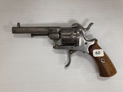gros plan d'un revolver sur une surface blanche