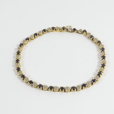 un bracelet composé de perles dorées et noires sur fond blanc