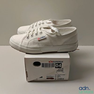 a pair of white shoes sitting on top of a box