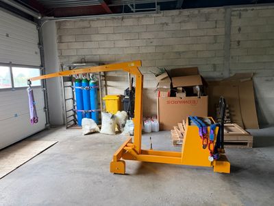une grande grue jaune dans un garage où se trouvent de nombreux cartons