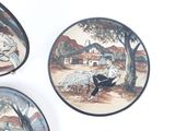 three plates with a painting of a man and a dog on them