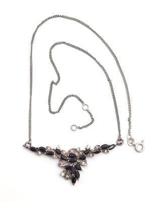 gros plan d'un collier sur une surface blanche avec une chaîne