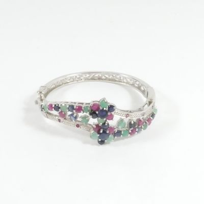un gros plan d'une bague en argent sertie de pierres multicolores