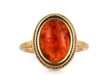 une image représentant une bague en or jaune sertie d'une pierre rouge