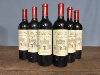 six bottles of red wine are lined up on a wooden table