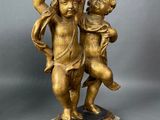 an antique bronze statue of a boy and a girl on a marble base