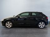 the black audi is parked in a room with a gray floor