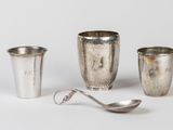 trois tasses et cuillères en argent posées les unes à côté des autres sur une surface blanche