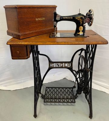 une vieille machine à coudre posée sur une table en bois