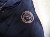navy blue jacket with a gold logo on the front