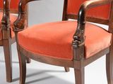 pair of orange upholstered armchairs with carved wood arms