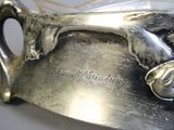 a silver plate with a dog on it on a table