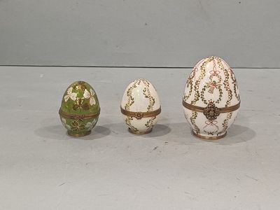 three decorated eggs sitting next to each other on a table