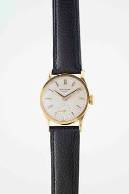 a close up of a watch on a black leather strap