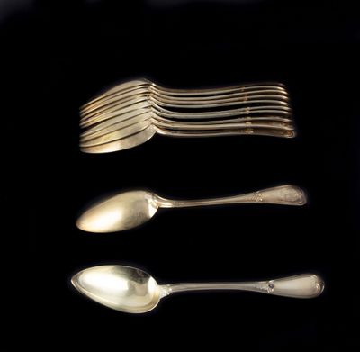 Plusieurs cuillères et fourchettes sont disposées en rangée sur une surface noire