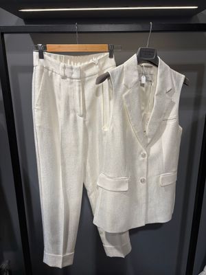 une photo d'un costume blanc et d'une cravate suspendus à un cintre