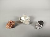 three different types of rocks and crystals on a white surface