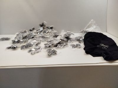 a pile of silver and black items on a white table