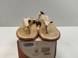 pair of women ' s gold sandals in a box on a white surface