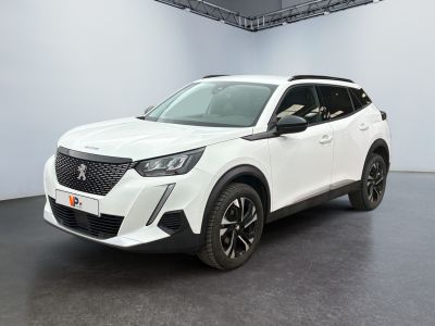 Le SUV blanc est garé dans une grande pièce au sol noir.