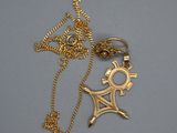 Gros plan sur un collier en or orné d'une croix