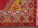 an old red and yellow rug with a design on it