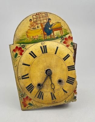 a small clock with a painting on the face