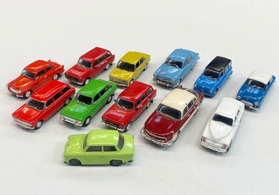 several toy cars are lined up in a row on a white surface