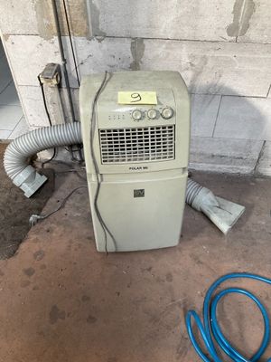 a small air conditioner sitting on the floor next to a hose